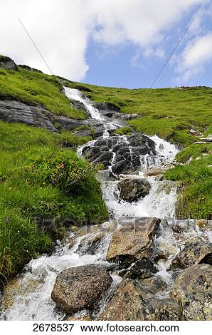 Stock Photo - Water flowing on rocks, Trentino-Alto Adige, Italy . Fotosearch