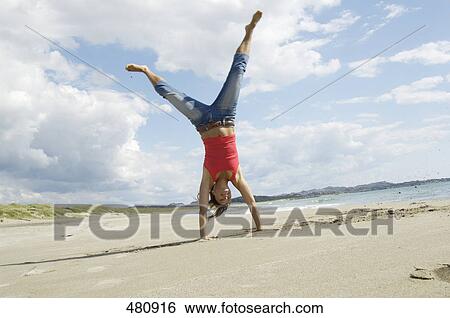 Woman doing cartwheel on beach View Large Photo Image Stock Photograph - Woman doing cartwheel on beach . Fotosearch