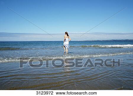 Woman entering the water, rear view View Large Photo Image Stock Image - Woman entering the water, rear view . Fotosearch