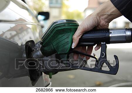 Stock Photograph - Woman refueling car at gas station . Fotosearch