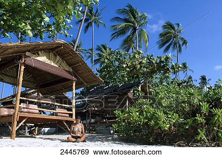 Woman sitting in front of bamboo hut on beach View Large Photo Image Stock Photo - Woman sitting in front of bamboo hut on beach . Fotosearch