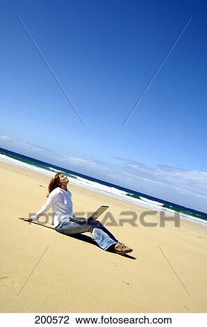 Woman sitting with laptop at beach View Large Photo Image Stock Image - Woman sitting with laptop at beach . Fotosearch