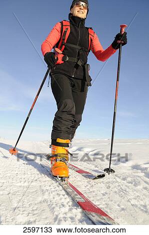 Stock Image - Woman skiing on snow-covered landscape, Trentino-Alto Adige, Italy . Fotosearch
