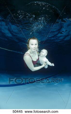 Woman swimming underwater with his baby in swimming pool View Large Photo Image Stock Photography - Woman swimming underwater with his baby in swimming pool . Fotosearch