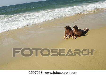 Young couple lying on beach View Large Photo Image Stock Photo - Young couple lying on beach . Fotosearch