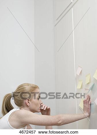 Stock Photo - Young woman leaning against wall . Fotosearch