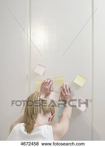 Stock Photo - Young woman leaning against wall . Fotosearch