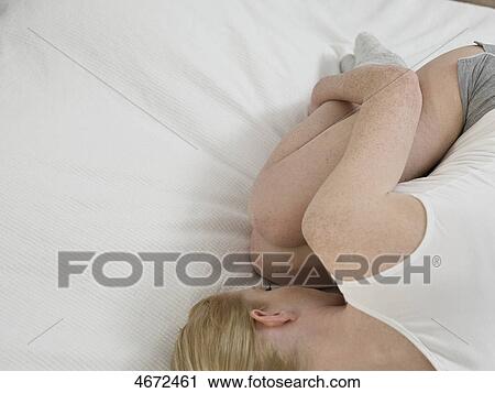 Young woman lying on bed View Large Photo Image Stock Image - Young woman lying on bed . Fotosearch