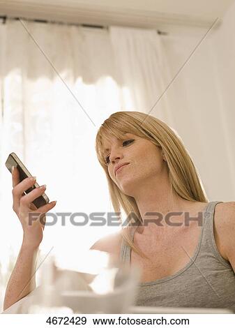 Stock Photo - Young woman phoning in bed . Fotosearch