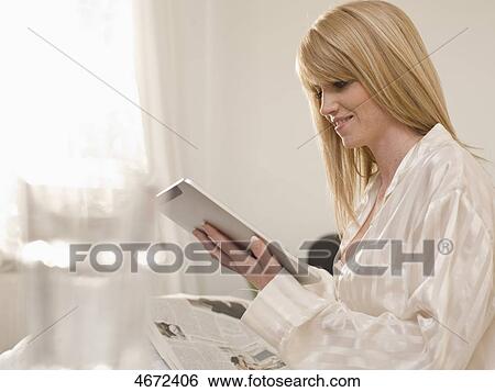 Young woman sitting in bed View Large Photo Image Stock Photograph - Young woman sitting in bed . Fotosearch