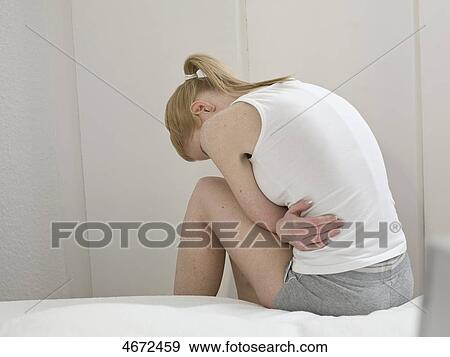 Young woman sitting on bed View Large Photo Image Stock Photo - Young woman sitting on bed . Fotosearch