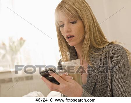 Stock Photo - Young woman with newspaper in bed . Fotosearch