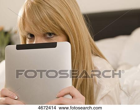 Picture - Young woman with Tablet PC in bed . Fotosearch