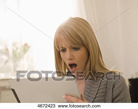 Stock Image - Young woman with Tablet PC in bed . Fotosearch