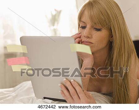 Young woman with Tablet PC in bed View Large Photo Image Stock Image - Young woman with Tablet PC in bed . Fotosearch
