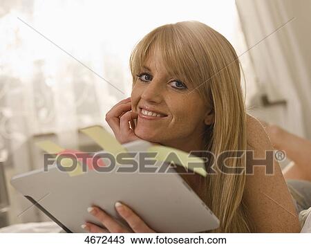 Stock Image - Young woman with Tablet PC in bed . Fotosearch
