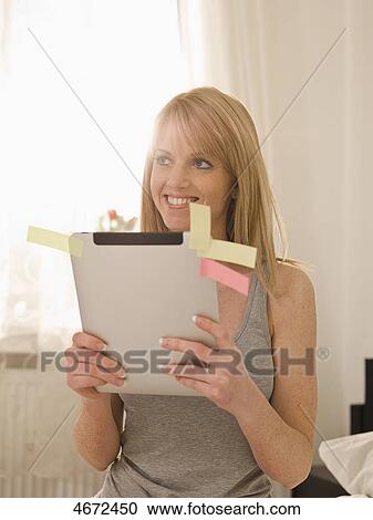 Stock Image - Young woman with Tablet PC in bed . Fotosearch