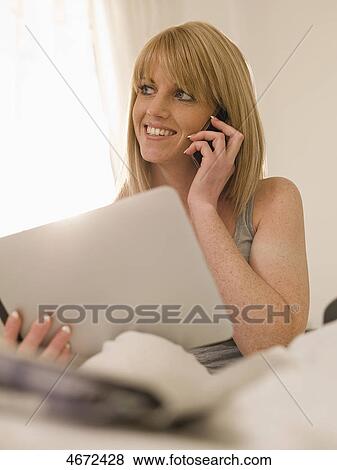 Stock Photo - Young woman with Tablet PC in bed . Fotosearch