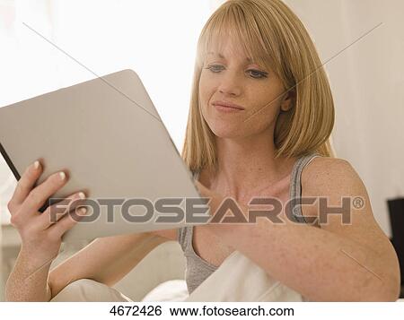 Young woman with Tablet PC in bed View Large Photo Image Stock Photograph - Young woman with Tablet PC in bed . Fotosearch
