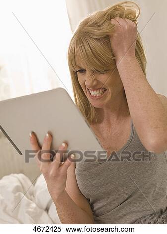 Stock Photography - Young woman with Tablet PC in bed . Fotosearch