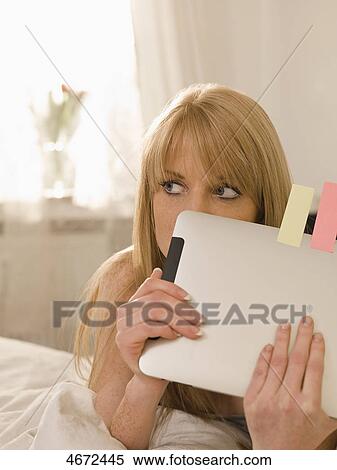 Stock Photography - Young woman with Tablet PC in bed . Fotosearch