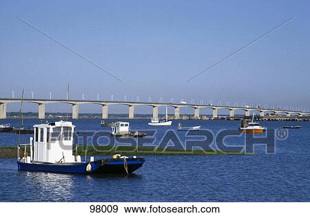 Stock Photo - Boats in river near a bridge, France . Fotosearch