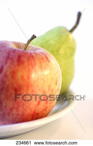 Stock Image - Close-up of apple and pear on plate . Fotosearch