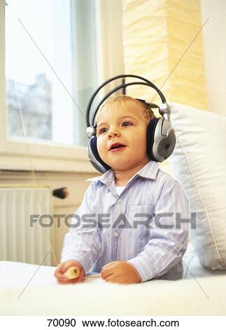 Stock Image - Close-up of boy wearing headphones and listening to music . Fotosearch