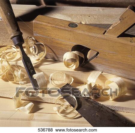 Stock Photo - Close-up of chisel and saw with wood shavings . Fotosearch