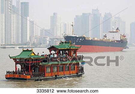 Stock Image - Ferry and ship on a river, Skyscrapers in the background, Shanghai, China . Fotosearch