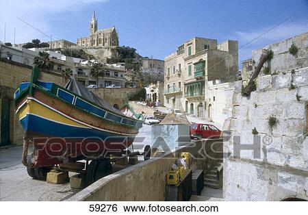Stock Photograph - Fishing boat at port, Our Lady's Church, Gozo, Mgarr, Malta . Fotosearch