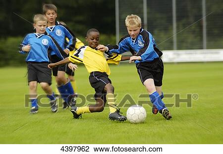 Stock Image - Five boys playing football . Fotosearch