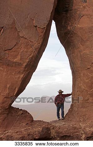 Stock Photography - Man standing on rock formation, Monument Valley, Arizona, USA . Fotosearch