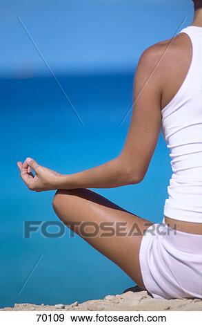 Mid section view of young woman meditating on beach View Large Photo Image Stock Photo - Mid section view of young woman meditating on beach . Fotosearch