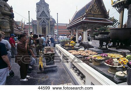 Stock Photo - People making religious offering at temple, Wat Phra Kaeo, Bangkok, Thailand . Fotosearch