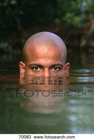 Stock Image - Portrait of young man swimming in lake . Fotosearch