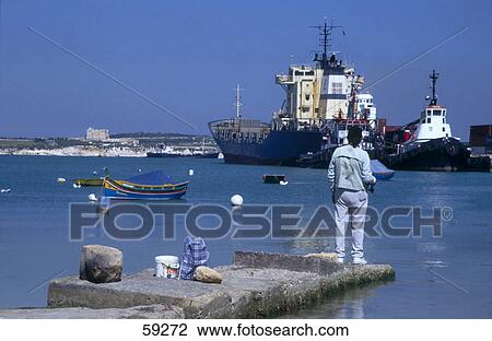 Rear view of man standing at harbor, Malta, Europe View Large Photo Image Stock Image - Rear view of man standing at harbor, Malta, Europe . Fotosearch