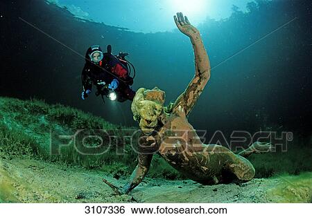 Stock Photograph - Scuba diver discovering Nixie of King Ludwig in the Badersee, Germany, Bavaria, underwater shot . Fotosearch