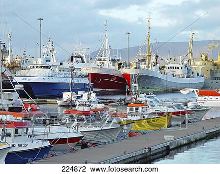 Stock Image - Ships and boats at harbor under overcast sky, Reykjavyk, Iceland . Fotosearch