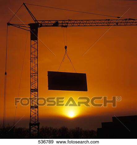 Silhouette of crane lifting metal at dusk View Large Photo Image Stock Photo - Silhouette of crane lifting metal at dusk . Fotosearch