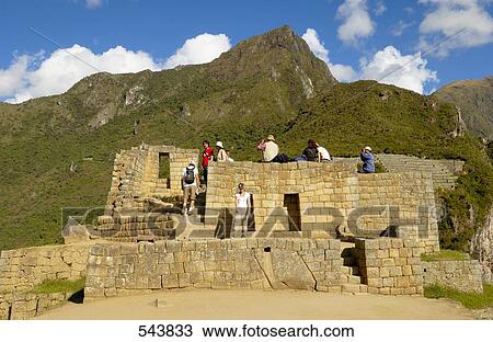 Stock Image - Tourists looking at old ruins, Inca Ruins, Machu Picchu, Cusco Region, Peru . Fotosearch