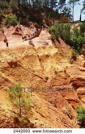 Stock Image - Tourists walking on rocky mountain, Vaucluse, Provence-Alpes-Cote D'azur, France . Fotosearch