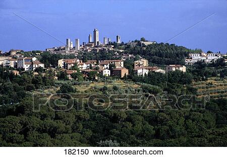 Trees on landscape with town in background, San Gimignano, Tuscany, Italy View Large Photo Image Stock Image - Trees on landscape with town in background, San Gimignano, Tuscany, Italy . Fotosearch