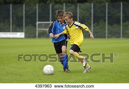 Stock Image - Two boys playing football . Fotosearch