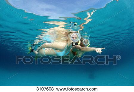 Stock Photo - Two young woman snorkeling, Bali, Indian Ocean, underwater shot . Fotosearch