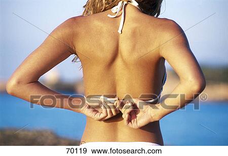 Young woman closing bikini, rear view View Large Photo Image Stock Photo - Young woman closing bikini, rear view . Fotosearch