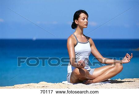 Young woman in yoga position at beach, full shot View Large Photo Image Stock Photo - Young woman in yoga position at beach, full shot . Fotosearch