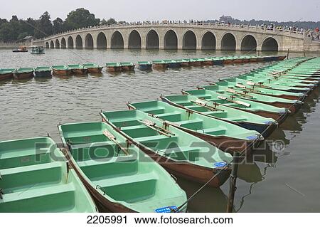 Boats moored in row near bridge View Large Photo Image Stock Image - Boats moored in row near bridge . Fotosearch