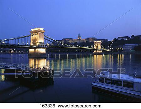 Bridge across river lit up at night View Large Photo Image Stock Photograph - Bridge across river lit up at night . Fotosearch