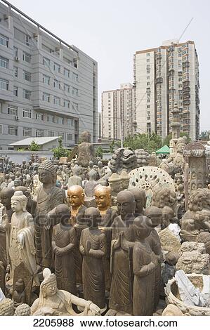 Buddha sculptures in front of buildings in city, China View Large Photo Image Stock Photo - Buddha sculptures in front of buildings in city, China . Fotosearch